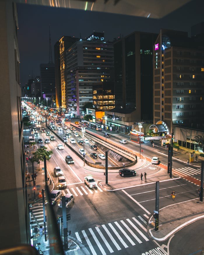 A bustling city intersection at night, with vibrant lights and busy traffic.
